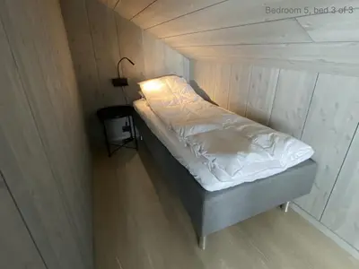 a small bed in a small room with a lamp at The Panoramic Chalet in Stranda