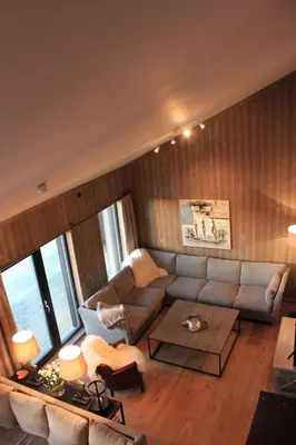 a living room with a couch and a table at Hafjelltoppen-New apartment with a beautiful view and high standard in Hafjell