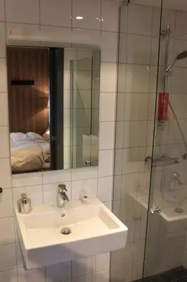 a bathroom with a sink and a shower with a mirror at Hafjelltoppen-New apartment with a beautiful view and high standard in Hafjell