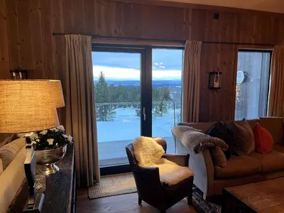 a living room with a couch and a large window at Hafjelltoppen-New apartment with a beautiful view and high standard in Hafjell