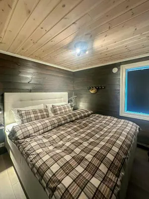 a bed in a room with a wooden ceiling at Modern Apartment At Strandafjellet Ski Resort in Stranda