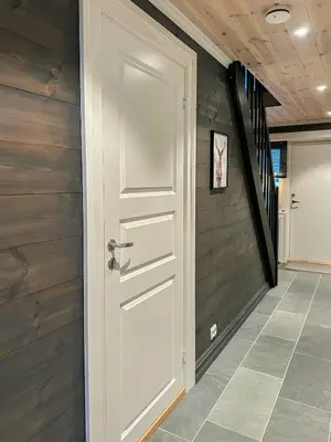 a hallway with a white door and a staircase at Modern Apartment At Strandafjellet Ski Resort in Stranda