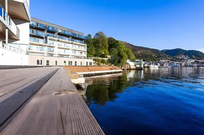 a building next to a body of water at Modern apartment by the sea in Bergen