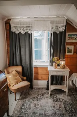 a living room with a chair and a window at Helgaker Gård in Gran