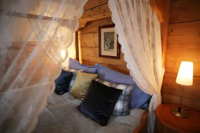 a room with a bed with curtains and pillows at Helgaker Gård in Gran