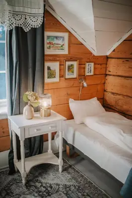 a bedroom with a bed and a table with a lamp at Helgaker Gård in Gran