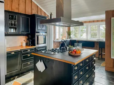 a kitchen with black cabinets and a bowl of fruit on a counter at Modern Cabin With Ski In-Out In Hafjell in Øyer