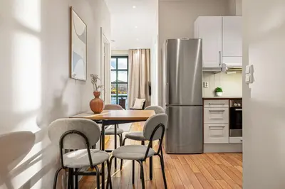 a kitchen with a table and chairs and a refrigerator at Heimby Homes - Balcony above the sea in Bergen