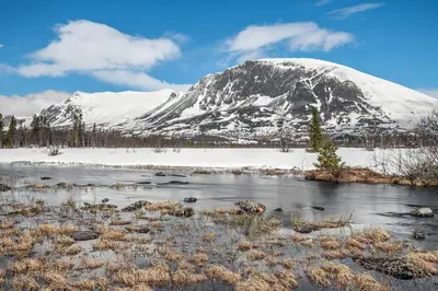 a snow covered mountain in front of a river at Apartment in Hemsedal in Hemsedal