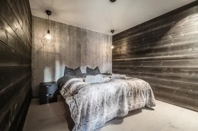 a bedroom with a large bed with a wooden wall at Apartment in Hemsedal in Hemsedal