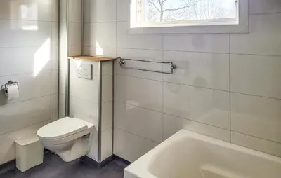 a white bathroom with a toilet and a bath tub at 1 Bedroom Amazing Apartment In Stord in Stord