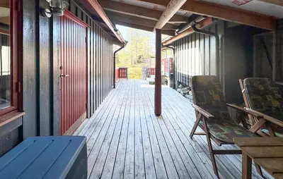 a porch of a building with a bench and chairs at Beautiful Home In Jordet With Sauna in Lybekk