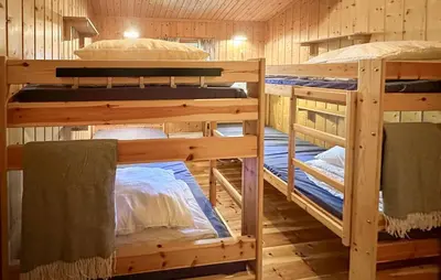 a room with three bunk beds in a cabin at Beautiful Home In Jordet With Sauna in Lybekk
