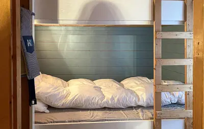 a bunk bed with white sheets on it at 3 Bedroom Amazing Home In Haddal in Haddal