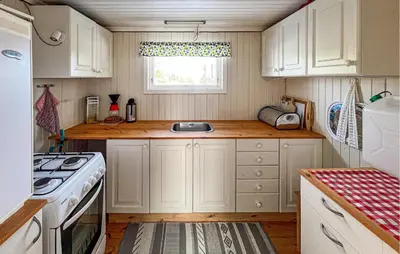 a small kitchen with white cabinets and a window at Beautiful Home In Vang På Hedmarken in Sæli