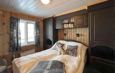 a dog sitting on a bed in a bedroom at Nice Home In Nord-Torpa With Sauna in Nord Torpa