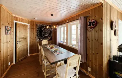 a dining room with a wooden table and chairs at Nice Home In Nord-Torpa With Sauna in Nord Torpa