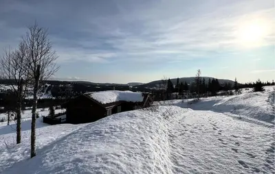 a snow covered hill with a building in the background at Nice Home In Nord-Torpa With Sauna in Nord Torpa