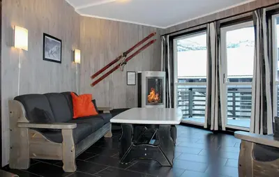 a living room with a couch and a table and a fireplace at Lovely Apartment In Hemsedal With Sauna in Hemsedal