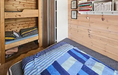 a bed in a room with a wooden wall at Nice Home In Rjukan With Wifi in Rjukan