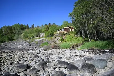 a house on a hill next to a rocky river at En perle i Trondheimsfjorden in Trondheim