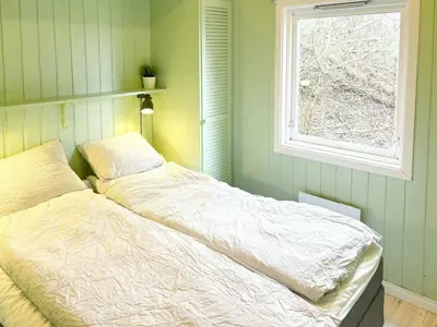 a bed in a bedroom with a window at Cabin By Lake Tyrifjorden With Water Views