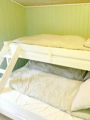 two bunk beds in a room with a bed at Cabin By Lake Tyrifjorden With Water Views