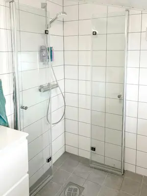 a shower with a glass door in a bathroom at Cabin By Lake Tyrifjorden With Water Views