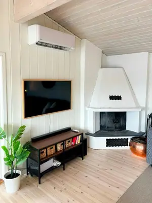 a living room with a fireplace and a tv at Cabin By Lake Tyrifjorden With Water Views