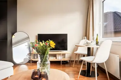 a living room with a vase of flowers on a table at Modern Suites, Excellent Location in the heart of Bergen in Bergen