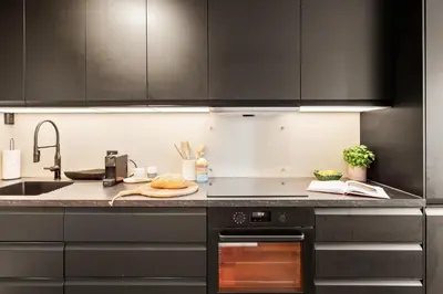 a kitchen with black cabinets and a sink at Modern Suites, Excellent Location in the heart of Bergen in Bergen