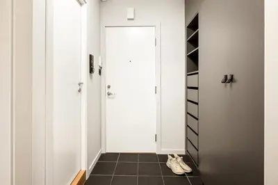 a hallway with a white door and a black tile floor at Modern Suites, Excellent Location in the heart of Bergen in Bergen