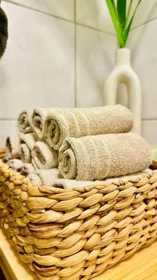 a basket with towels and a vase on a table at Modern Suites, Excellent Location in the heart of Bergen in Bergen
