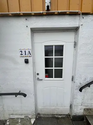 a white door with a window next to a building at Utsiken in Bergen