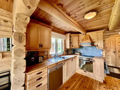 a kitchen with wooden cabinets and a sink at Traditional mountain cabin in Valdres in Blomstølen