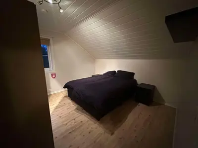a bedroom with a bed in the corner of a room at Leiligheit i Hornindal in Volda