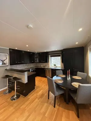 a kitchen with a table and chairs in a room at Leiligheit i Hornindal in Volda