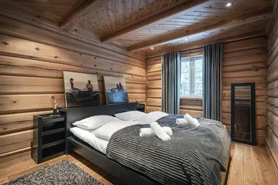 a bedroom with wooden walls and a bed with white pillows at Vacation house in Hemsedal in Hemsedal