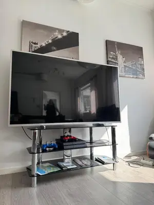 a large flat screen tv on a stand in a living room at Sentral fantastisk leilighet in Øvre Årdal