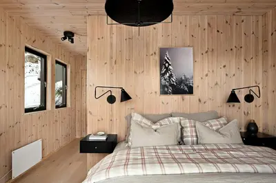 a bedroom with wood paneled walls and a bed at Cabin Overlooking Ryfylke Fjord in Høyvik
