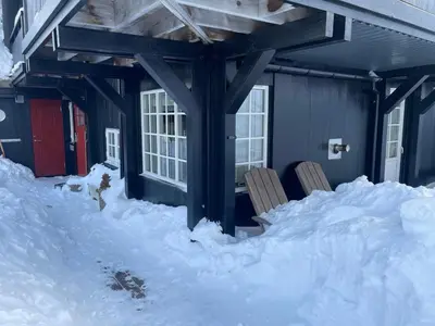 a house covered in snow with two chairs in it at Fully equipped ski-in ski-out apartment at Kikut, Geilo in Geilo