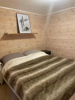 a bedroom with a large bed with wooden walls at Fully equipped ski-in ski-out apartment at Kikut, Geilo in Geilo