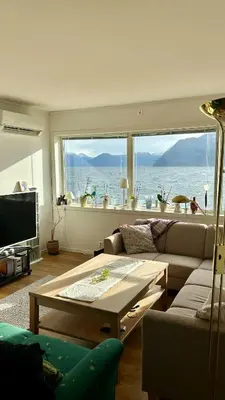 a living room with a couch and a table at Live right by the Sognefjord in Sogndal