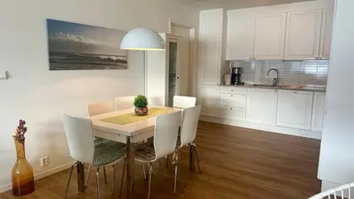a kitchen and dining room with a table and chairs at Live right by the Sognefjord in Sogndal