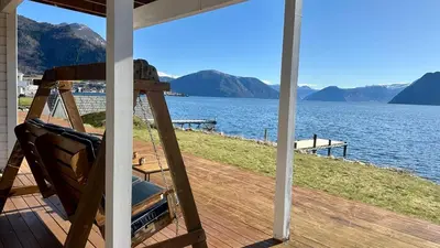 a porch of a house with a view of the water at Live right by the Sognefjord in Sogndal