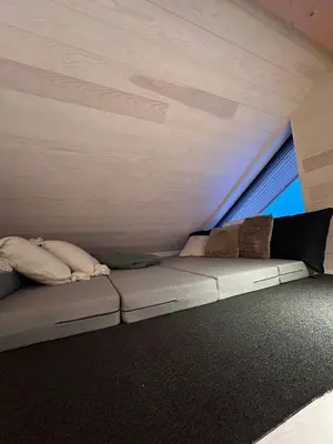 a small couch in a room with a window at Modern Cabin With A Personal Touch in Sogndal