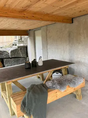 a table and a bench under a wooden ceiling at Modern Cabin With A Personal Touch in Sogndal