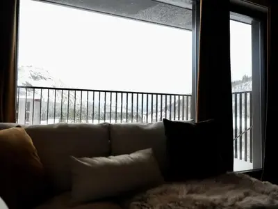 a living room with a couch and a large window at Ski in & out - Hemsedal in Kyrkjebøen