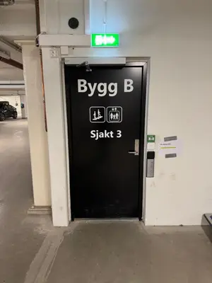 a black door with a sign on it in a parking garage at Ski in & out - Hemsedal in Kyrkjebøen