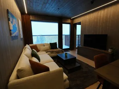 a living room with a white couch and a television at Ski in & out - Hemsedal in Kyrkjebøen